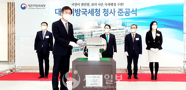 대전지방국세청 청사신축기념 타임캡슐에 김대지 국세청장이 기념사진을 넣고 있다.