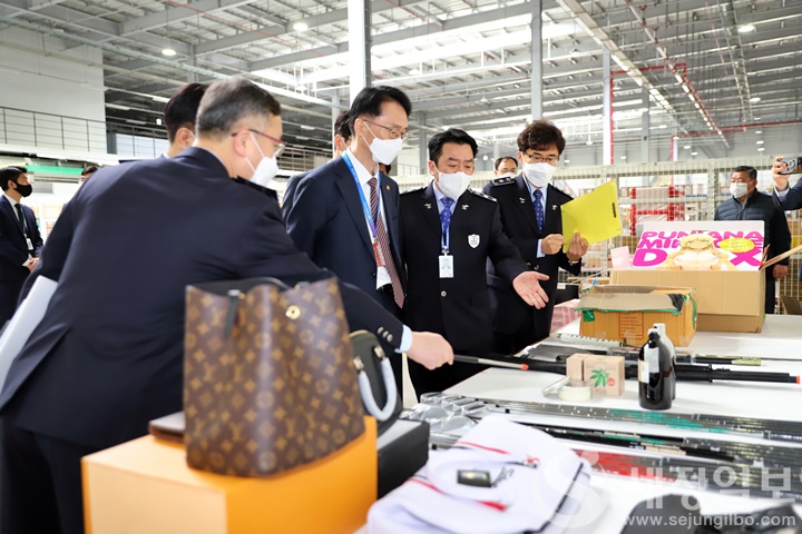 임재현 관세청장이 특송물류센터에서 특송으로 반입된 위조물품을 확인하는 장면을 특송통관1과장의 설명을 들으면 살펴 보고 있다. [관세청 제공]