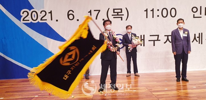 구광회 대구지방세무사회장이 연임에 성공한후 회기를 힘차게 흔들어 보이고 있다.