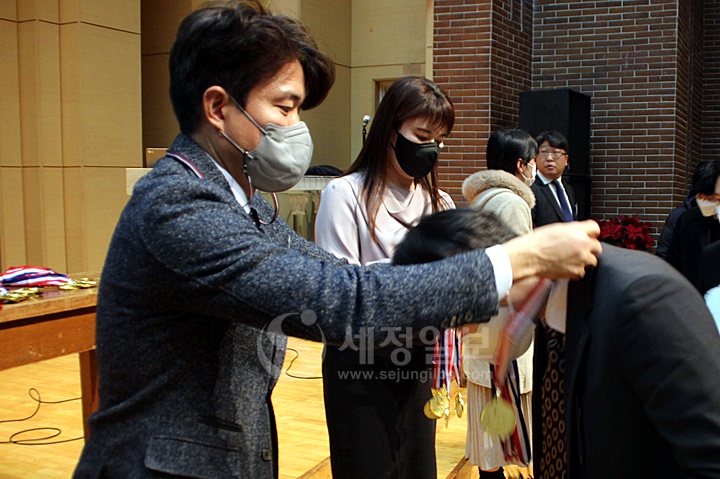 한국세무사고시회 전통에 따라 선배 회원들이 신입 후배 회원들에게 메달을 걸어주고 있다.