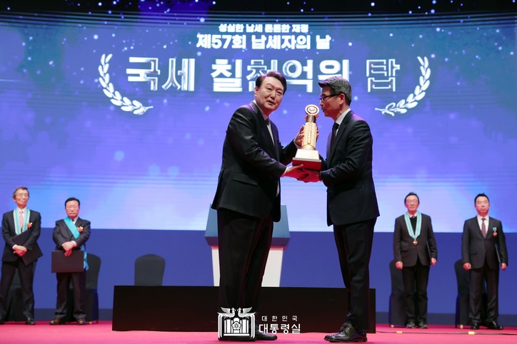 윤석열 대통령으로부터  기아 주식회사가 국세 칠척억원 탑을 전달받고 있다. [대통령실 제공]