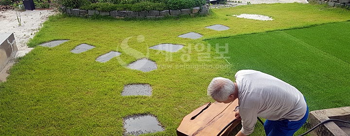 김승한 세무사가 통나무 의자를 옮기는 작업을 하고 있다.