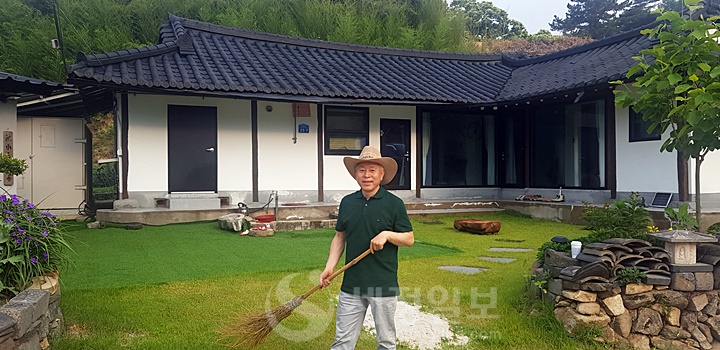 김승한 대표세무사가 100년이 넘은 한옥고택 잔디마당을 쓸고 있다.