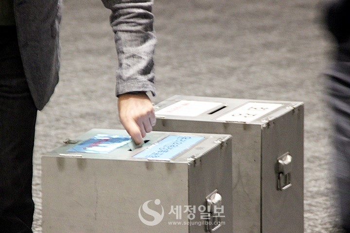 투표를 마친 회원들이 소중한 민의가 담긴 투표용지를 투표함에 넣고있다.