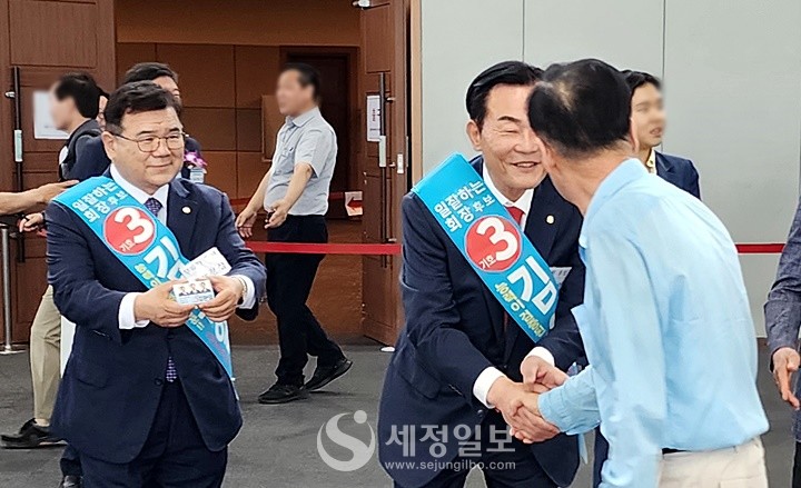 '일 잘하는 회장 후보'라고 쓴 어깨띠를 두른 김완일 후보가 장경상 부회장 후보와 함께 인천회원들에게 자신을 지지해 달라면서 약수하고 있다.