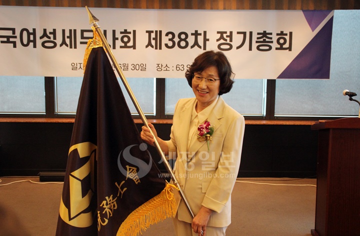 한국여성세무사회 회기를 들어보이고 있는 황영순 여성세무사회장.