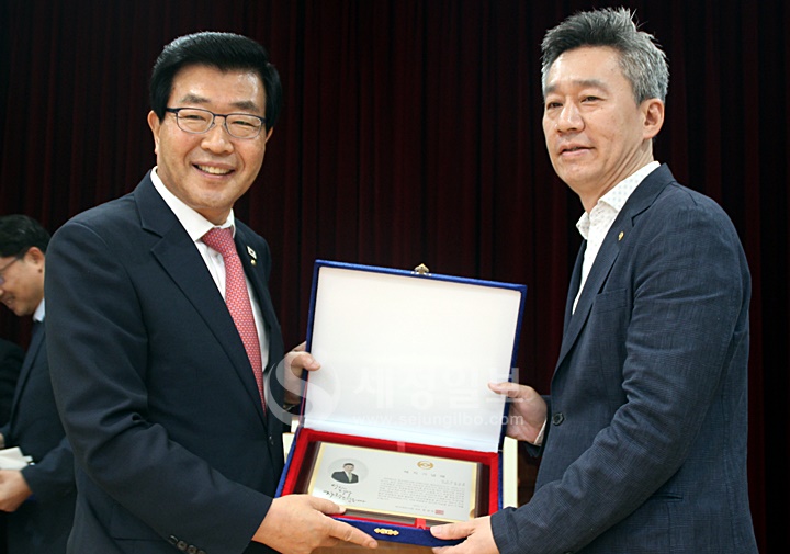 경준호 이사에게 제32대 한국세무사회 임원 재직기념패를 전달하고 있다.