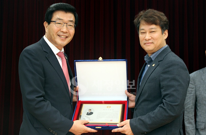김신언 연구이사에게 제32대 한국세무사회 임원 재직기념패가 전달되고 있다.