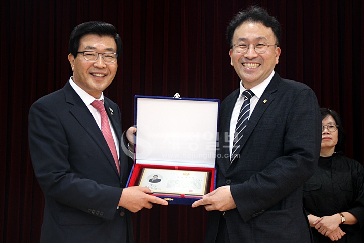 정동원 총무이사에게 제32대 한국세무사회 임원 재직기념패를 전달하고 있다.