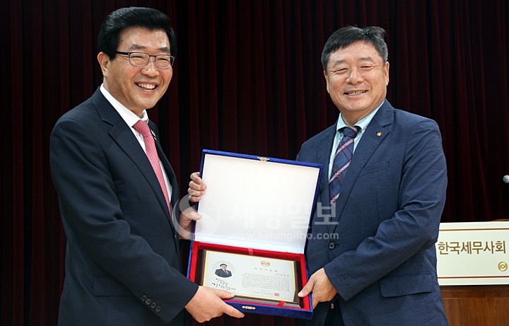 김명진 인천지방세무사회장이 제32대 한국세무사회 임원 재직기념패를 받고 있다.