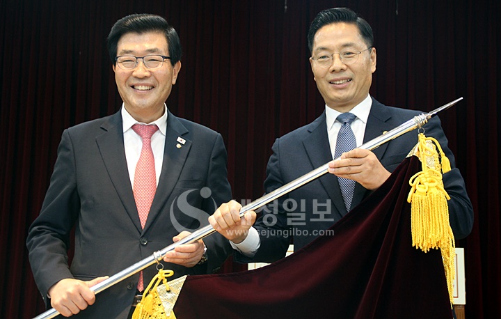 한국세무사회 회기가 신임 구재이 한국세무사회장에게 전달되고 있다.