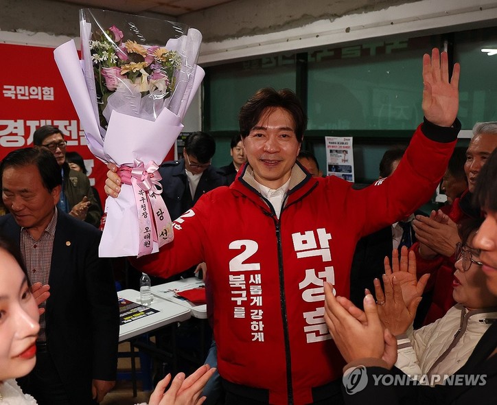 국민의힘 박성훈 북구을 후보가 11일 오전 당선이 확정되자꽃다발을 들고 환호하고 있다. 박 후보는 개표율 70%까지 뒤처지다 막판 역전에 성공했다.