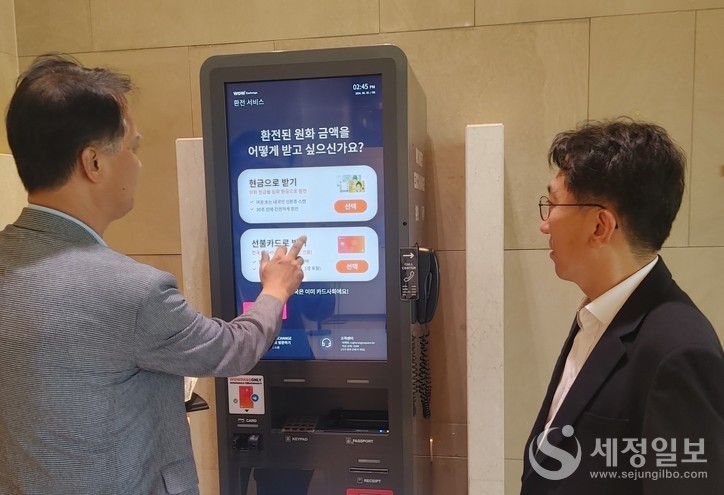 한창령 관세청 조사국장(오른쪽)이 서울 구로구에 설치된 무인환전기에서 외국인 관광객의 이용 현장을 둘러보고 있다. [관세청 제공]