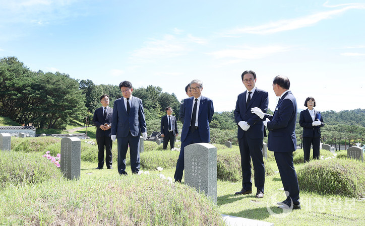 강민수 국세청장 및 간부들이 국립5·18민주묘지를 찾아 참배하고 김범태 묘지관리소장으로부터 설명을 듣고 있다. (좌측부터 홍영표 광주청 운영지원과장, 박광종 광주지방국세청장, 김정수 비서관, 김휘영 국세청 대변인, 원순석 5·18기념재단 이사장, 강민수 국세청장, 김범태 묘지관리소장)