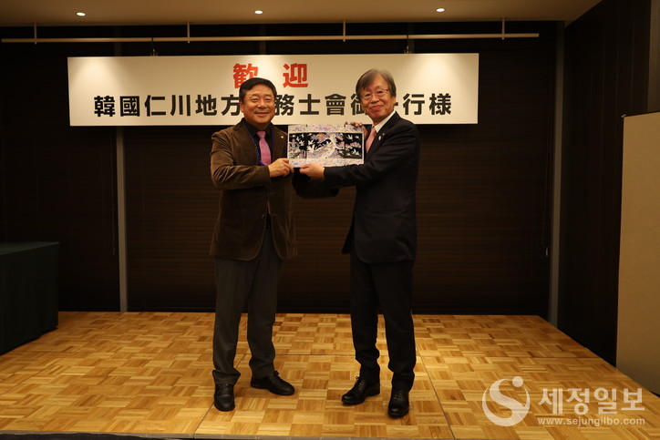 김명진 회장이 마루야마 쓰구야 회장에게 기념품을 전달하고 있다.