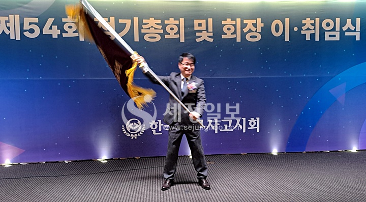 장보원 신임 세무사고시회장이 이석정 전임 회장으로부터 회기를 넘겨 받아 힘차게 흔들어 보이고 있다.