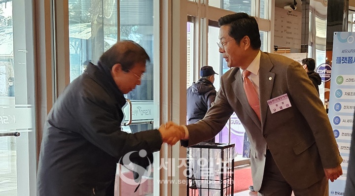 구재이 세무사회장이 보수교육에 참석하는 회원과 악수하고 있다.