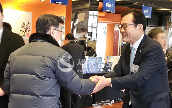 김완일 전 서울세무사회장이 보수교육에 참석하는 회원과 악수하고 있다.