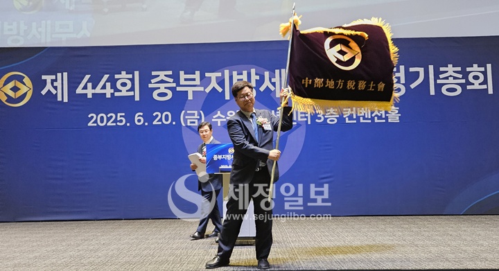 이재실 신임 중부지방세무사회장이 회기를 힘차게 흔들어 보이고 있다.