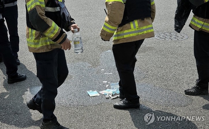 동울산세무서 분신 시도 현장. 26일 오전 10시 49분께 울산 북구 동울산세무서 청사 앞 야외주차장에서 50대 남성 민원인이 분신을 시도해 2명이 중경상을 입었다. 사진은 출동한 소방대원들이 현장을 정리하는 모습.